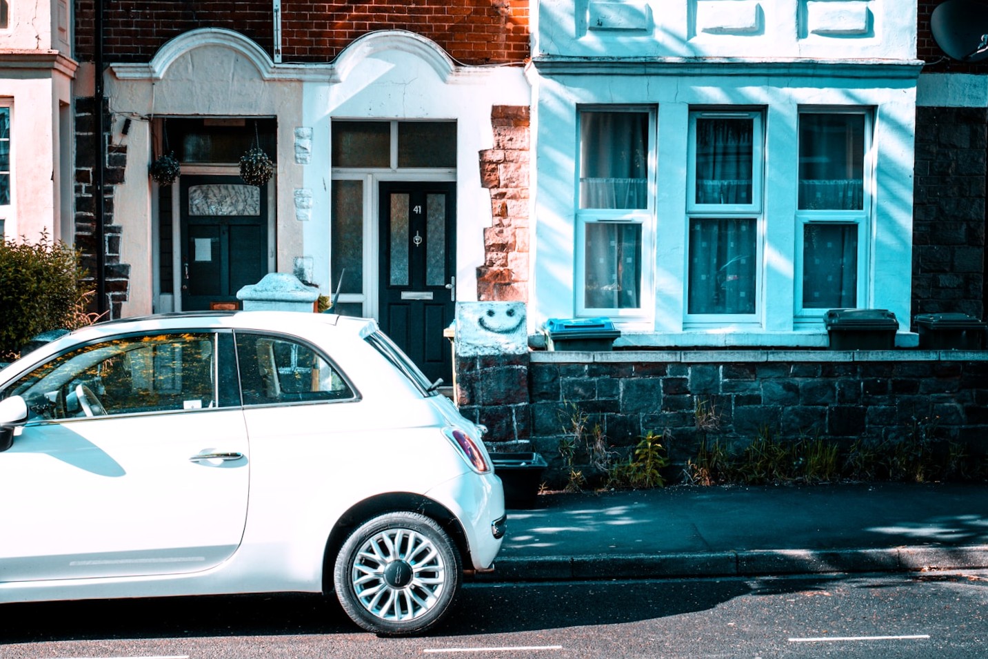 A modern car parked safely on a residential road in the UK, representing a learner driver preparing to book their practical test under the new official DVSA driving test booking rules.